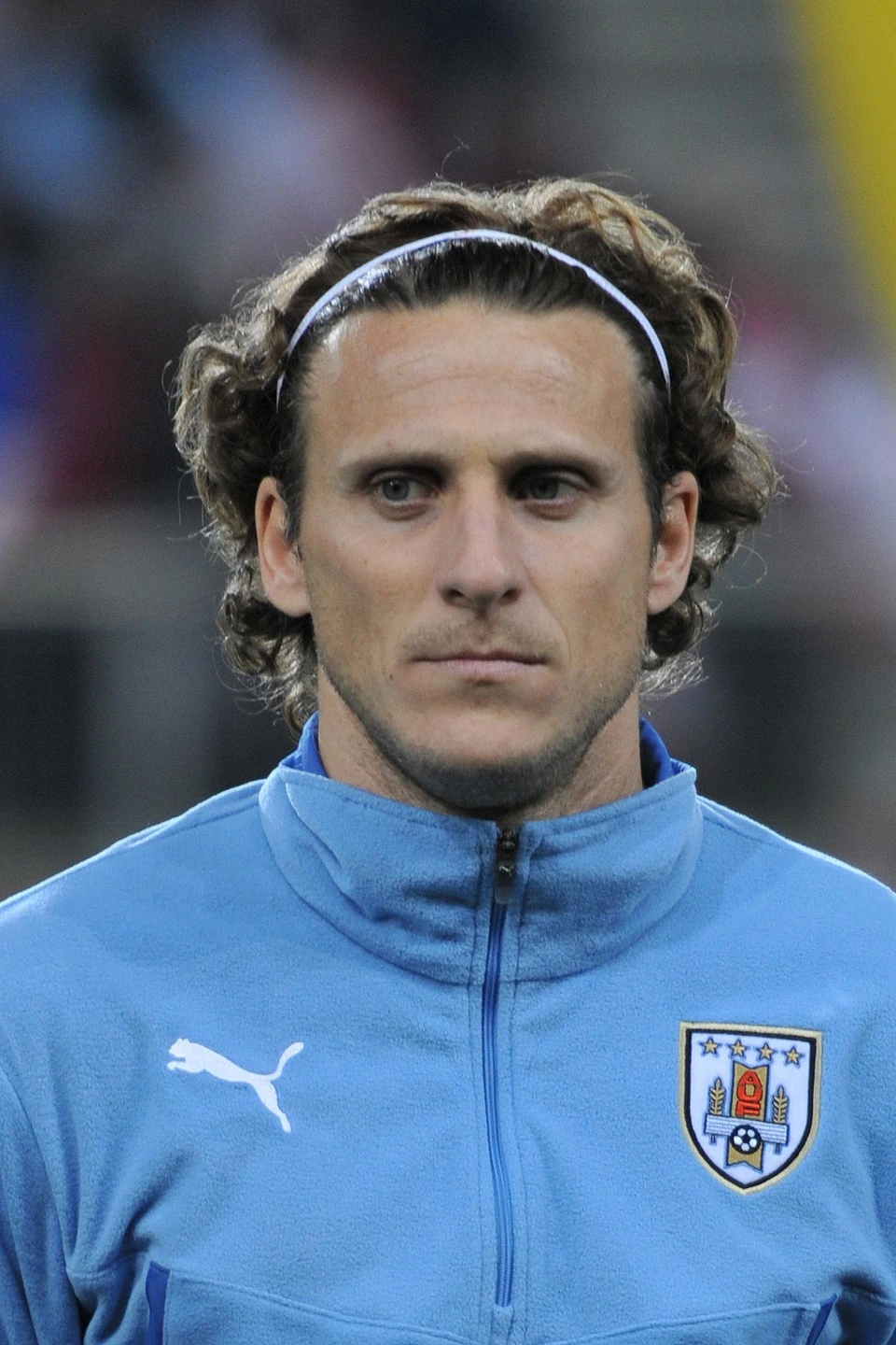 Diego Forlán in a Uruguay training jacket, close-up portrait with stadium background